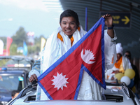 Nepalese youngest record holder climber Nima Rinji Sherpa poses with the national flag for a photo after arriving at Tribhuvan International...