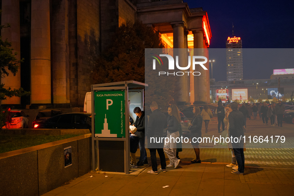 People wait in line to pay parking tickets in Warsaw, Poland on 12 October, 2024. 