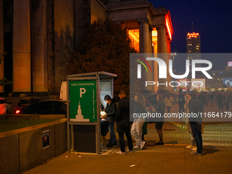 People wait in line to pay parking tickets in Warsaw, Poland on 12 October, 2024. (