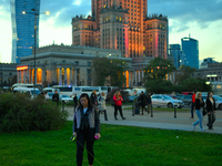 A woman walks a dog in front of the Palace of Culture and Sciences in Warsaw, Poland on 12 October, 2024. (