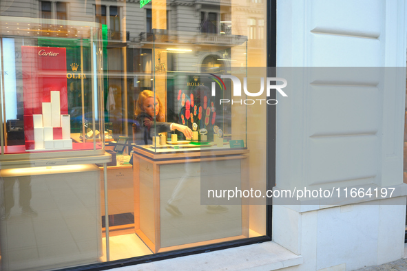 A woman places a box in a Rolex watch display at a shop in Warsaw, Poland on 12 October, 2024. 