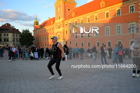 An elderly man is seen dancing on the Royal Castle square in Warsaw, Poland on 12 October, 2024. 