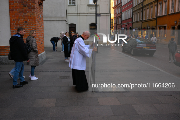 A clergyman sets up a sign outside a church in Warsaw, Poland on 12 October, 2024. 