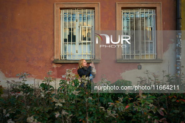 A woman takes a photograph of the setting sun with her mobile phone in Warsaw, Poland on 12 October, 2024. 