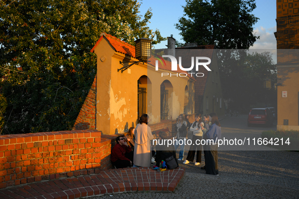 Young people are seen gathered in the Old Town while the sun sets in Warsaw, Poland on 12 October, 2024. 