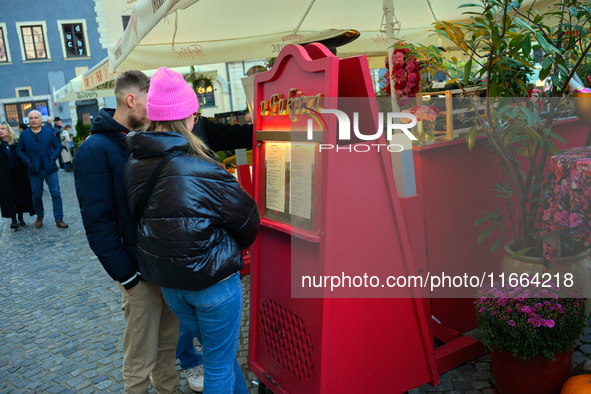 People look at a restaurant menu in Warsaw, Poland on 12 October, 2024. 