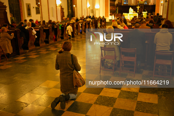 A woman is seen praying in a church in Warsaw, Poland on 12 October, 2024. 