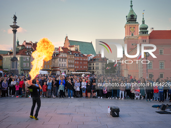 A street performer is seen spitting fire and flames in Warsaw, Poland on 12 October, 2024. (