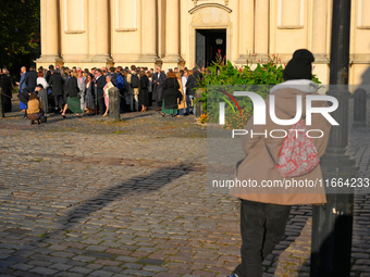 A man looks on as people gather outside a church after a wedding ceremony in Warsaw, Poland on 12 October, 2024. (