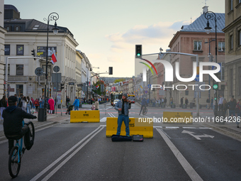 A busker playing a violin on a street closed for traffic is seen in Warsaw, Poland on 12 October, 2024. (