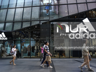 People walk past a shopping mall and the popular Siam Square shopping area in Bangkok, Thailand, on October 14, 2024. (