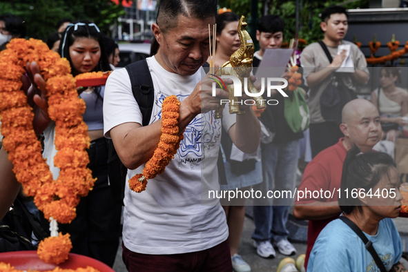 Thais and foreign tourists worship a statue of Lord Brahma, the Hindu god of creation, for good fortune at the Erawan Shrine in Bangkok, Tha...