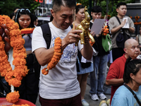 Thais and foreign tourists worship a statue of Lord Brahma, the Hindu god of creation, for good fortune at the Erawan Shrine in Bangkok, Tha...