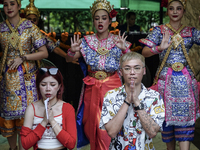 Devotees pray as dancers perform while worshiping Lord Brahma, the Hindu god of creation, for good fortune at the Erawan Shrine in Bangkok,...