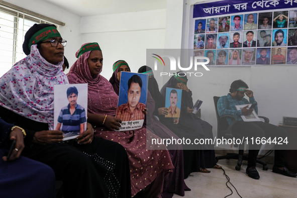 Family members of the victims of enforced disappearance hold portraits of their disappeared relatives during a press conference at the Natio...