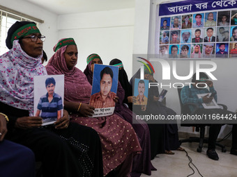 Family members of the victims of enforced disappearance hold portraits of their disappeared relatives during a press conference at the Natio...