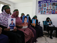 Family members of the victims of enforced disappearance hold portraits of their disappeared relatives during a press conference at the Natio...