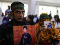 Family members of the victims of enforced disappearance hold portraits of their disappeared relatives during a press conference at the Natio...