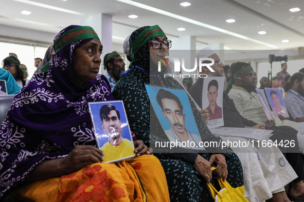 Family members of the victims of enforced disappearance hold portraits of their disappeared relatives during a press conference at the Natio...