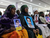 Family members of the victims of enforced disappearance hold portraits of their disappeared relatives during a press conference at the Natio...