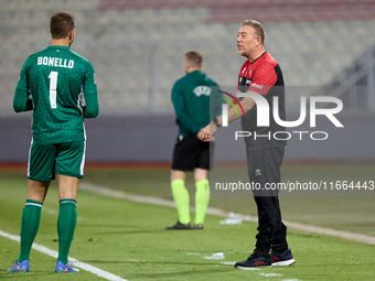 In Ta' Qali, Malta, on October 13, 2024, Davide Mazzotta, interim coach of Malta, speaks with Henry Bonello, goalkeeper of Malta, during the...