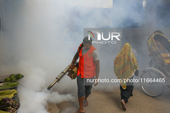 A city corporation worker sprays fumigator to control mosquitoes as the number of dengue-infected patients increases in Dhaka, Bangladesh, o...