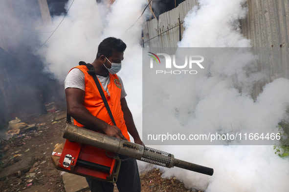 A city corporation worker sprays fumigator to control mosquitoes as the number of dengue-infected patients increases in Dhaka, Bangladesh, o...