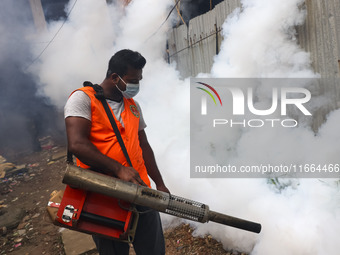 A city corporation worker sprays fumigator to control mosquitoes as the number of dengue-infected patients increases in Dhaka, Bangladesh, o...