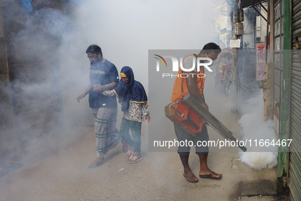 A city corporation worker sprays fumigator to control mosquitoes as the number of dengue-infected patients increases in Dhaka, Bangladesh, o...