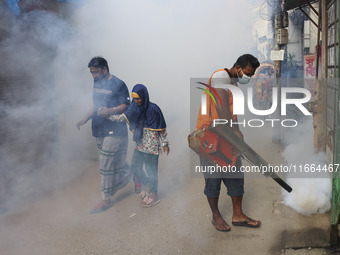 A city corporation worker sprays fumigator to control mosquitoes as the number of dengue-infected patients increases in Dhaka, Bangladesh, o...