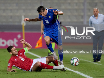 In Ta' Qali, Malta, on October 13, 2024, Maxim Cojocaru of Moldova is closely challenged by Matthew Guillaumier of Malta during the UEFA Nat...