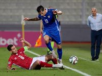 In Ta' Qali, Malta, on October 13, 2024, Maxim Cojocaru of Moldova is closely challenged by Matthew Guillaumier of Malta during the UEFA Nat...