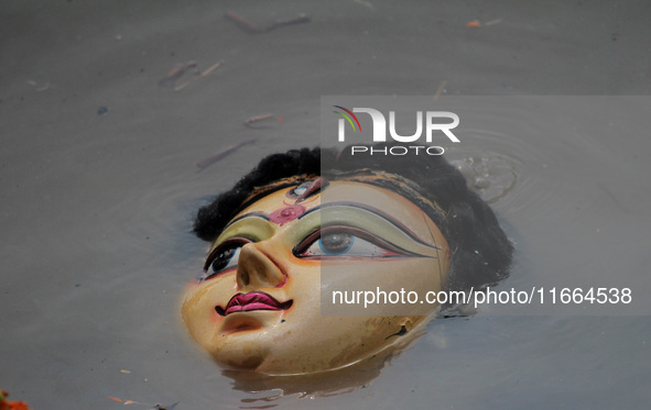 An idol of Goddess Durga is seen in the waters of the Kuakhai River as devotees immerse it, marking the conclusion of the 10-day Durga Puja...