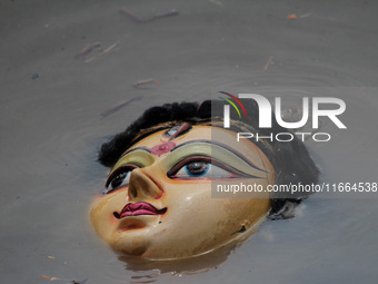 An idol of Goddess Durga is seen in the waters of the Kuakhai River as devotees immerse it, marking the conclusion of the 10-day Durga Puja...