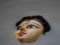 An idol of Goddess Durga is seen in the waters of the Kuakhai River as devotees immerse it, marking the conclusion of the 10-day Durga Puja...