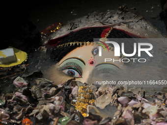 An idol of Goddess Durga is seen in the waters of the Kuakhai River as devotees immerse it, marking the conclusion of the 10-day Durga Puja...