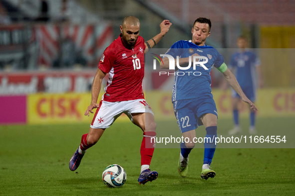 In Ta' Qali, Malta, on October 13, 2024, Teddy Teuma of Malta is closely followed by Vadim Rata of Moldova during the UEFA Nations League, L...