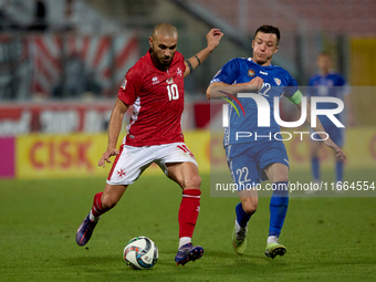 In Ta' Qali, Malta, on October 13, 2024, Teddy Teuma of Malta is closely followed by Vadim Rata of Moldova during the UEFA Nations League, L...