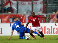 In Ta' Qali, Malta, on October 13, 2024, Basil Tuma of Malta is challenged by Vladislav Babogio of Moldova during the UEFA Nations League, L...