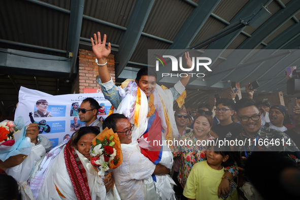 Nima Rinji Sherpa, 18, is cheered by friends and family upon his arrival at Tribhuvan International Airport after setting the world record a...