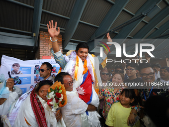 Nima Rinji Sherpa, 18, is cheered by friends and family upon his arrival at Tribhuvan International Airport after setting the world record a...