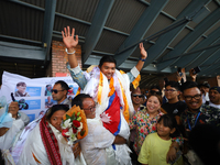 Nima Rinji Sherpa, 18, is cheered by friends and family upon his arrival at Tribhuvan International Airport after setting the world record a...