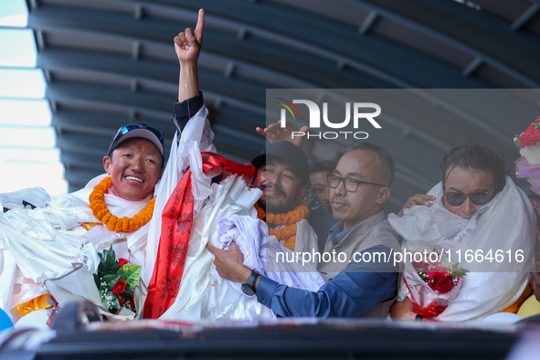 Record-setting climber Nirmal Purja, also known as Nimsdai, signals victory as he arrives back in Kathmandu, Nepal, on October 14, 2024, aft...