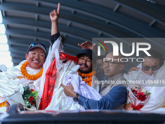 Record-setting climber Nirmal Purja, also known as Nimsdai, signals victory as he arrives back in Kathmandu, Nepal, on October 14, 2024, aft...