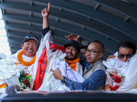 Record-setting climber Nirmal Purja, also known as Nimsdai, signals victory as he arrives back in Kathmandu, Nepal, on October 14, 2024, aft...