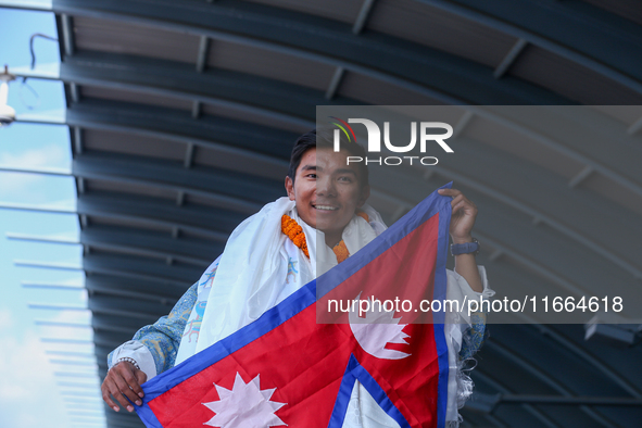 Nima Rinji Sherpa, 18, waves the Nepali national flag as he receives a heroic welcome upon his return to Nepal at Tribhuvan International Ai...