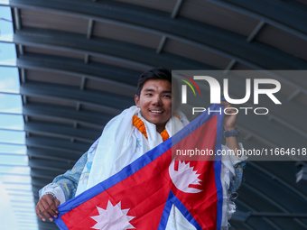 Nima Rinji Sherpa, 18, waves the Nepali national flag as he receives a heroic welcome upon his return to Nepal at Tribhuvan International Ai...