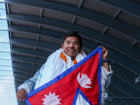 Nima Rinji Sherpa, 18, waves the Nepali national flag as he receives a heroic welcome upon his return to Nepal at Tribhuvan International Ai...