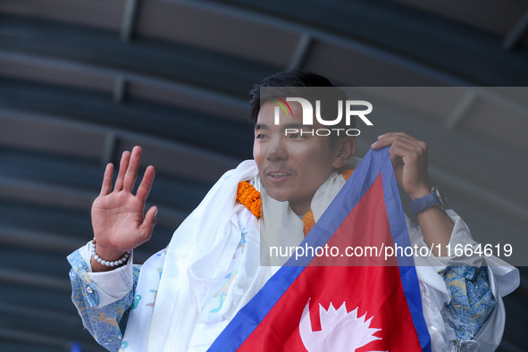 Nima Rinji Sherpa, 18, the youngest summiteer to climb all 14 of the world's peaks towering over 8000 meters, waves as he arrives at Tribhuv...