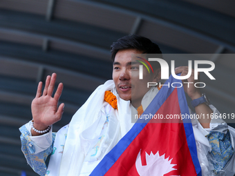 Nima Rinji Sherpa, 18, the youngest summiteer to climb all 14 of the world's peaks towering over 8000 meters, waves as he arrives at Tribhuv...